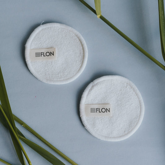 Two reusable bamboo makeup remover pads flat lay on a white background.