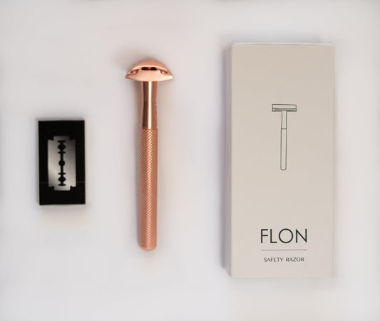 Eco-friendly reusable safety razor in rose gold brass with plastic-free packaging.
