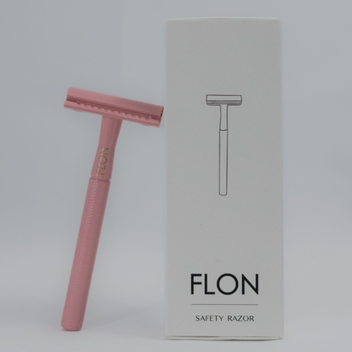 Sustainable reusable safety razor in brass with FLON packaging on grey background.