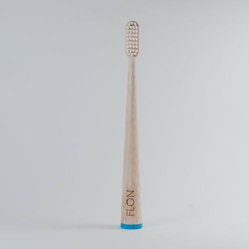 Eco-friendly adult bamboo toothbrush with BPA-free bristles and blue base, vegan and sustainable.