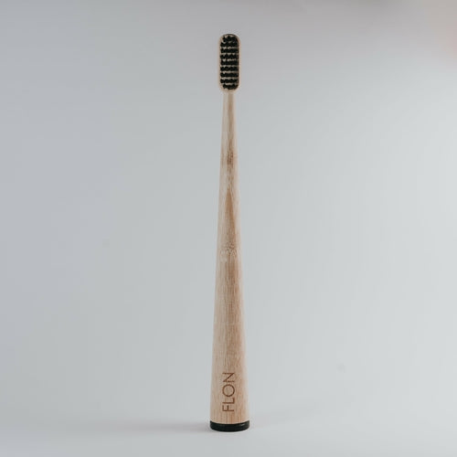 Plastic-free bamboo toothbrush with BPA-free bristles and black base, adult size, biodegradable.