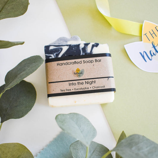 Into the Night soap bar with eucalyptus, tea tree and charcoal, handmade and plastic-free, styled with greenery.