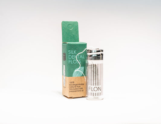 Natural silk dental floss in refillable glass dispenser with box, vegan and plastic-free oral care.