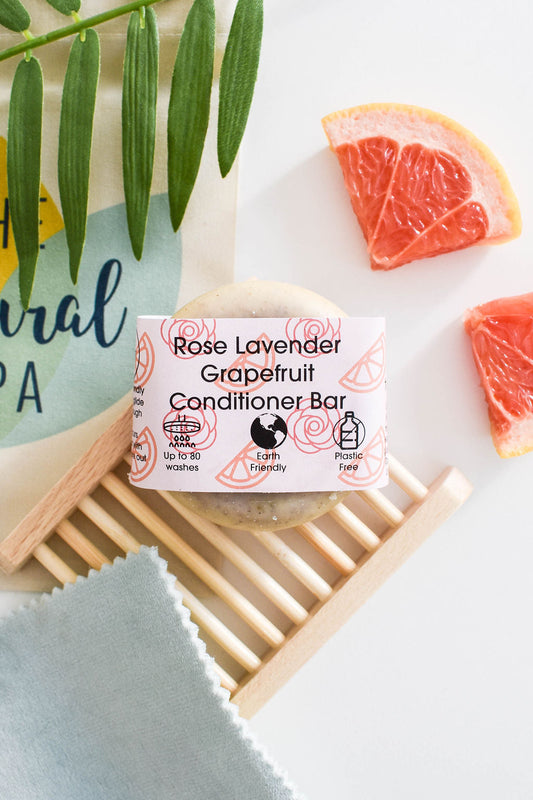 Solid conditioner bar with rose, grapefruit and lavender, vegan and plastic-free, styled with citrus and greenery.