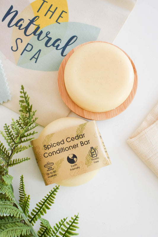 Solid conditioner bar with kraft label and greenery on light background.